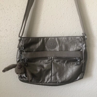 Bolso Bandolera Kipling Angie Para Mujer Metálico Gris Plateado con Dije L94507 Foto 1 de 4