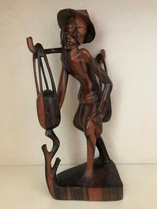 Exquisita escultura de Suar tallada a mano de un hombre que lleva agua de Bali - Imagen 1 de 8