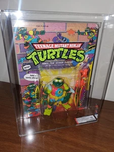 Tortugas Ninja AFA 85 NM+ 1990 TMNT Mike The SEWER SURFER sin perforar sin usar, en caja, Clear Bub - Imagen 1 de 11