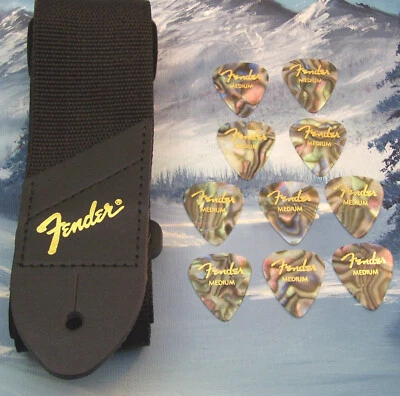 CORREA DE GUITARRA ~ GUARDABARROS GENUINO ~ NEGRA con LOGO DORADO + 10 PÚAS MEDIANAS DE ABULÓN Foto 1 de 2