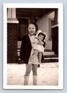 Fotografia vintage bambina tiene grande bambola nella neve sorridente felice - Foto 1 di 2