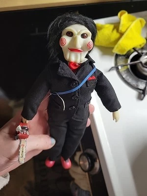 Figura de peluche Saw Movie Billy The Puppet Jigsaw NECA muñeca de 9" con una sierra de juguete Foto 1 de 4