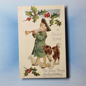 Geprägte Weihnachts Postkarte um 1907 Trompete braun Collie Hund Stechpalme Beeren - Bild 1 von 2