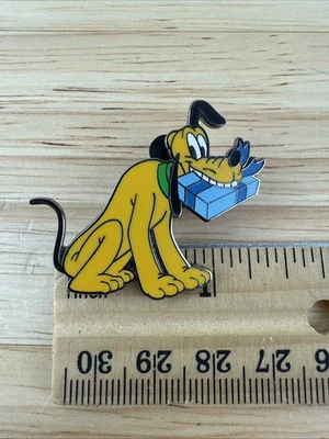 Prendedor de intercambio de Navidad Disney Plutón con regalo regalo en boca Foto 1 de 4