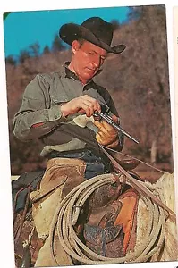 WESTERN COWBOY RICARICA la sua pistola pistola revolver cartolina cappello nero a cavallo - Foto 1 di 2