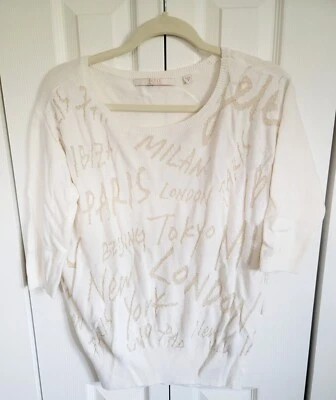 Suéter para mujer Guess M World Cities beige y dorado cuello redondo medio Slv Foto 1 de 4