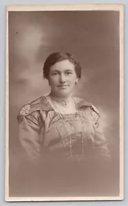 RPPC Freundliche Frau mit Deckchen Epilaten, Brosche, Halsketten. K Ltd. 1918-1936 - Bild 1 von 2