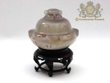 Lid bowl incense burner from agate on wooden base in beige and cream tones