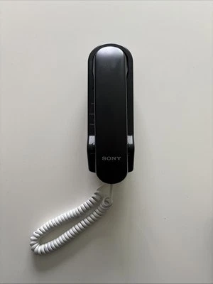 Teléfono fijo de una sola línea diseño delgado negro Sony ITB3 de colección cable blanco montaje en pared Foto 1 de 4