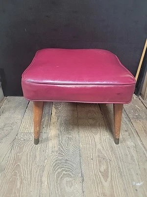 Taburete otomano vintage de vinilo rojo de mediados de siglo con patas cónicas de madera y metal Foto 1 de 4