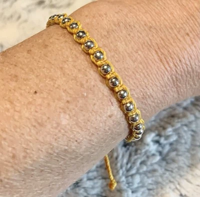 Brazalete ajustable trenzado amarillo mostaza con cuentas de metal Pura Vida  Foto 1 de 4