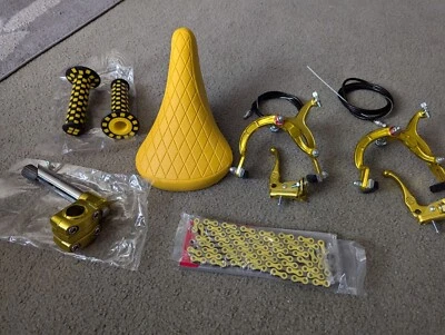 ASIENTO DE BICICLETA BMX NEGRO PATRÓN DIAMANTE, EMPUÑADURAS A CUADROS, CADENA, FRENOS DE MANO Y VÁSTAGO DORADOS Foto 1 de 3