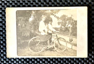 NIÑO Y NIÑA CON BICICLETA UNO ESTÁ EN LA BICICLETA RPPC POSTAL FOTO REAL - Imagen 1 de 2