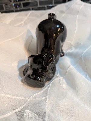 Cachorro preto pequeno de cerâmica em sua pose descendente de cachorro com uma pata cobrindo o olho - Imagem 1 de 4