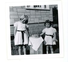Girls in matching dresses by birthday cake   vintage snapshot food photo  