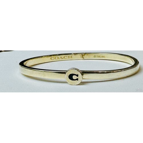 Bracciale con smalto firmato Coach oro con disegno a "C" nero