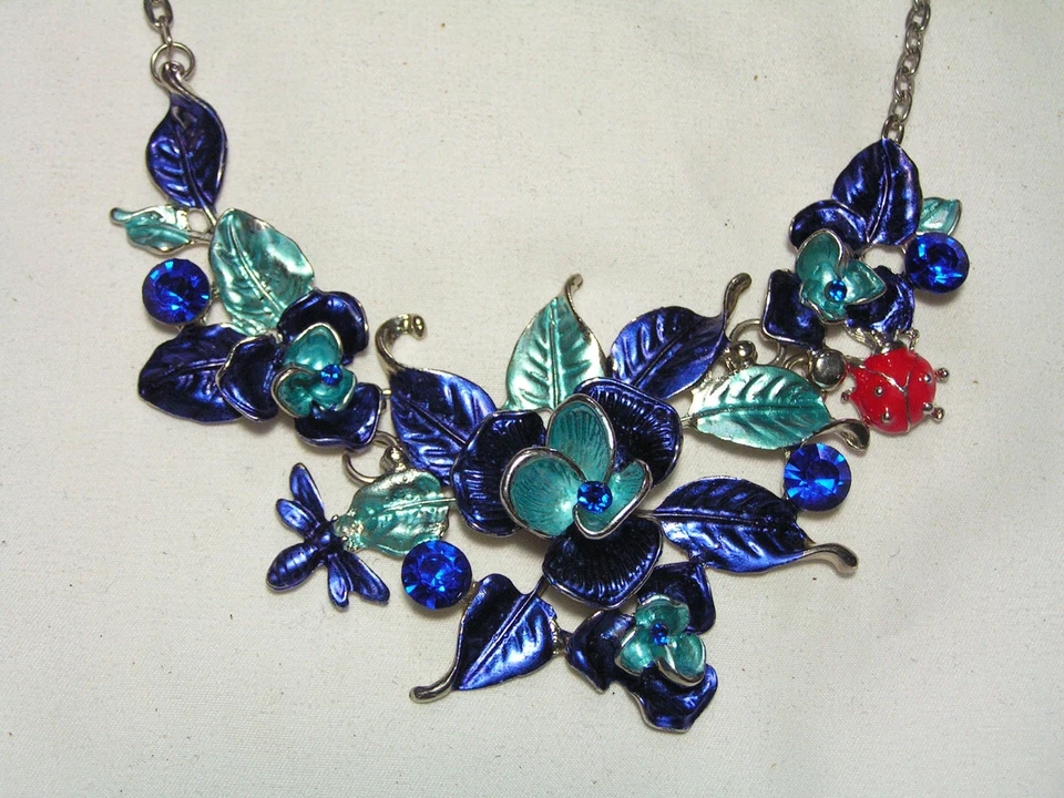 BETSEY JOHNSON... Collar colgante babero tono plata, cristales, flores esmaltadas e insectos Foto 1 de 4