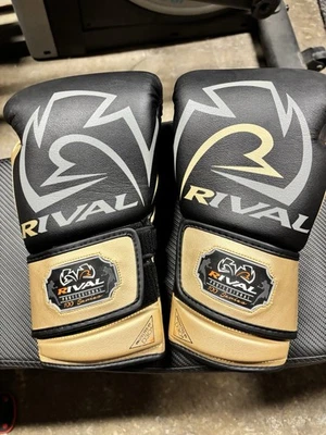 Rival RB100 Professional Boxing Bag Gloves Black/Gold, Large - Image 1 of 4