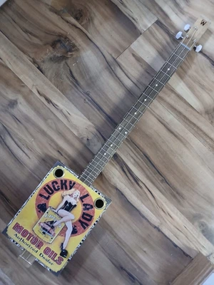GUITARRA ELÉCTRICA ACÚSTICA WEEKLYHOUSE CIGAR BOX 3 CUERDAS Lucky Lady Motor Oil Foto 1 de 4