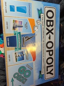 OBX OPOLY GIOCO DA TAVOLO - BANCHE ESTERNE NC - NUOVO, SIGILLATO E COMPLETO. - Foto 1 di 8