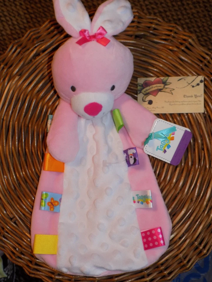 MANTA DE SEGURIDAD TAGGIES CONEJITO CONEJO ROSA COLORIDO FLATSIE MINKY DOT ABDOMEN TAGS Foto 1 de 4