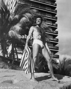 044 HUGH O'BRIAN PECHO PELUDO EN SPEEDO DE PIE FRENTE A LA PLAYA FOTO DE HOTEL - Imagen 1 de 1
