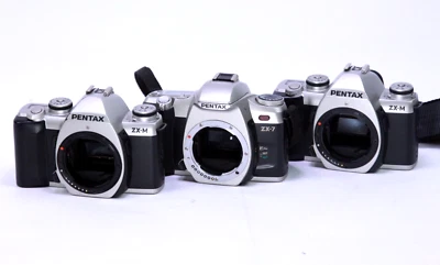 Lot of 3 Pentax ZX-M (2) & zx-7 (1) 35mm Camera bodies - Power on - Parts - Image 1 of 4