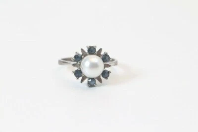 Ring Silberfarbender ring mit 6 Saphiren, einer Perle Zentrum Punze unleserlich  - Bild 1 von 3