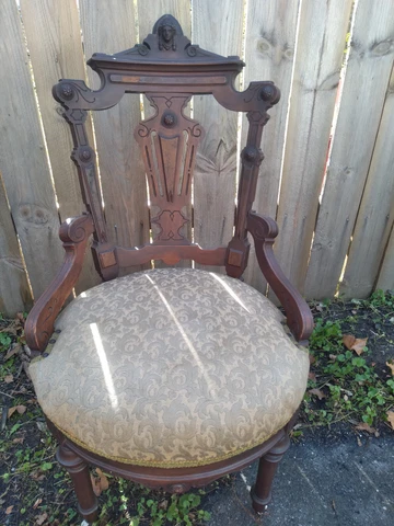 Antique Parlor Chair with Indian Head at the Top, Two Front Wheels Cover