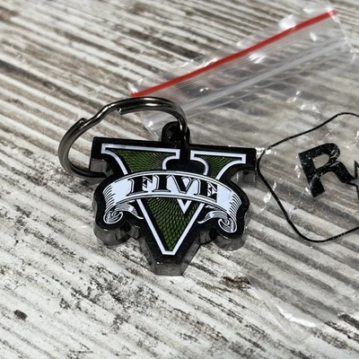 Grand Theft Auto V GTA V Logo Metal Rockstar Games AUTÉNTICO Llavero NUEVO Foto 1 de 4