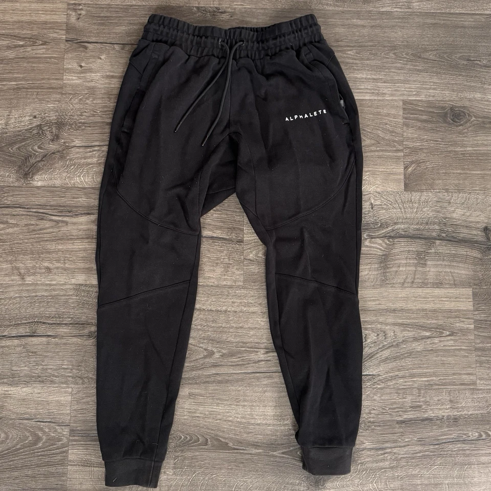 Pantalones de Gimnasio Alphalete Premium Trace Jogger Para Hombres Medianos Cónicos Pista de Entrenamiento Foto 1 de 4