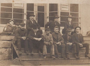 Hombres sentados en escalones en el banco Homburg sombreros gorras foto real RPPC c1920 postal - Imagen 1 de 3