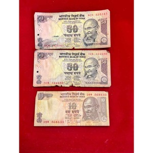 Three Indian bank notes. Two Fifty Rupee Bills and One 10 Rupee bill.