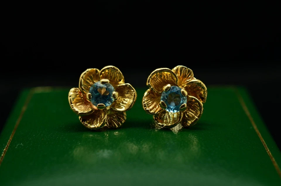 Aretes de topacio azul con montura de flores de oro amarillo de 14K Foto 1 de 4