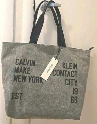 NOVA COM ETIQUETA BOLSA DE VIAGEM CALVIN KLEIN SELINA TOTE LONA CINZA/FORMA TRAPÉZIO TAMANHO GRANDE - Imagem 1 de 4