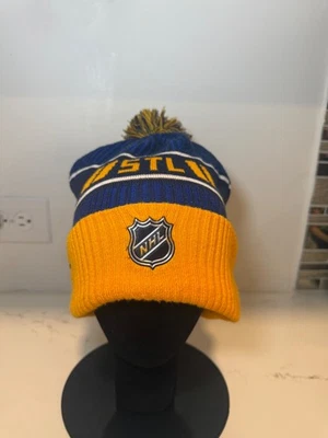 ST-LOUIS-BLUES-BEANIE-LOGO-AND-NAME-WITH-POMPOM-BLUE-YELLOW__BLUES-2021 - Image 1 of 4