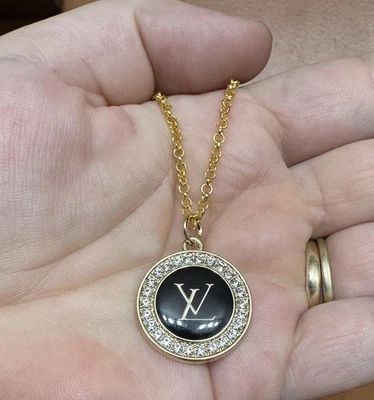 Precioso dije Louis Vuitton negro y dorado con pedrería Foto 1 de 3
