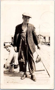 Fotografía antigua pescador en un muelle mostrando peces sombrero de noticiero foto sepia  - Imagen 1 de 2