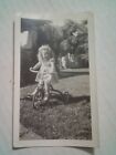 Photo vintage petite fille sur tricycle sur herbe