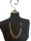 Chunky gold and layered silver chain necklace with black bow and ribbon neckline