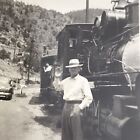 Vintage Black and White Photo Man Waving In Front Of Steam Engine Train Hills