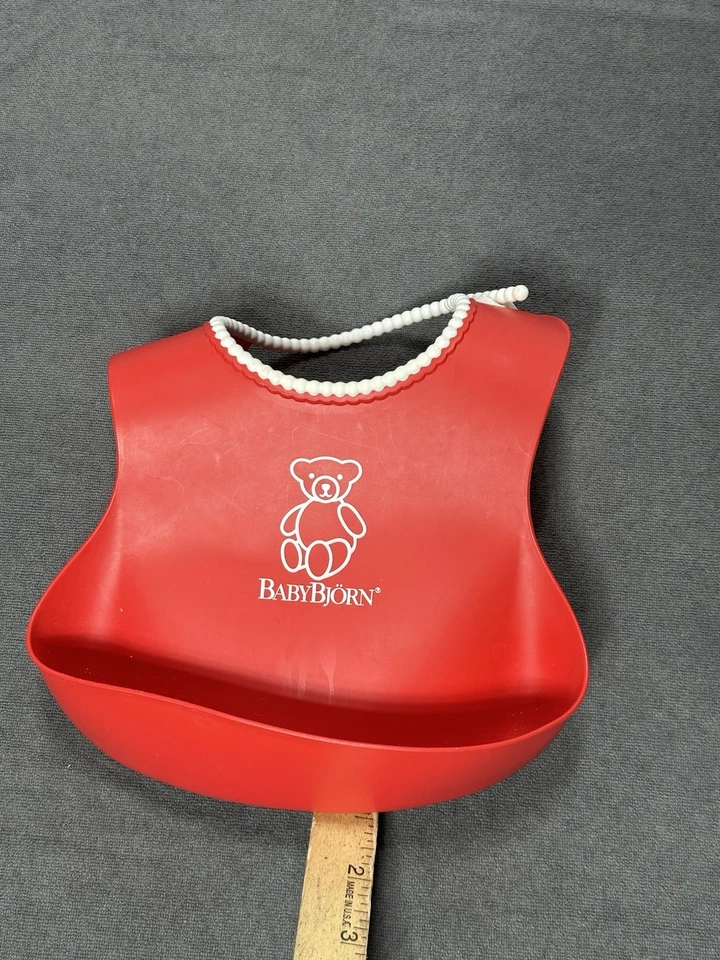 Babero Baby Bjorn Food Catching Silicona Rojo con Borde de Cuentas Blanco Bolsillo Profundo Foto 1 de 4