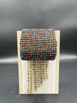 Brazalete ancho con pedrería multicolor tono dorado con flecos colgantes con cuentas Foto 1 de 4
