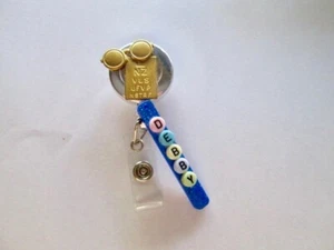 CARRETE RETRÁCTIL INSIGNIA DE IDENTIFICACIÓN, DIAGRAMA OCULAR, GAFAS, OPTOMETRISTA, OPTOMÓLOGO, OFICINA  - Imagen 1 de 2