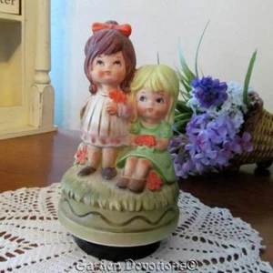 VINTAGE DREHBARE SPIELUHR 2 MÄDCHEN ZAUN GÄNSEBLÜMCHEN KLEIDER Best Friends - Bild 1 von 1