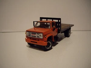 DCP FIRST GEAR 1/64 ORANGE CAB BLACK BULKHEAD GMC 6500 SINGLE AXLE FLATBED TRUCK - Picture 1 of 6