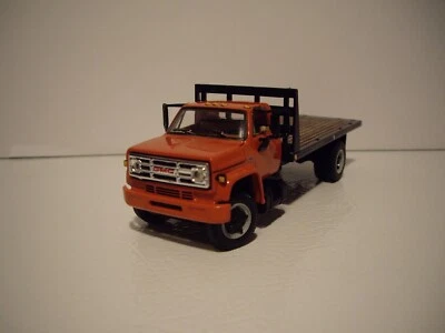 DCP FIRST GEAR 1/64 ORANGE CAB BLACK BULKHEAD GMC 6500 SINGLE AXLE FLATBED TRUCK - Image 1 of 4