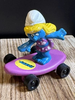 Juguete de comida Hardees Kids 1990 Pitufos - Pitufina en monopatín púrpura Foto 1 de 3