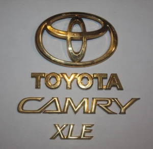 2002-2006 TOYOTA CAMRY XLE REAR TRUNK DECK LID GOLD EMBLEM SET COMPLETE OEM - Picture 1 of 1