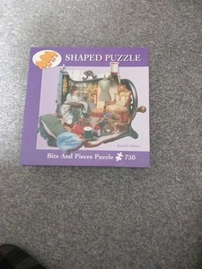 Bits and Pieces 750-teiliges Formpuzzle "A Stitch In Time" Russell Cobane - Bild 1 von 1
